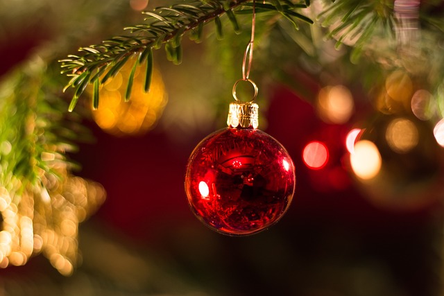 Imagen de una bola de Navidad colgando de un árbol decorado, capturando la esencia festiva de la temporada navideña.